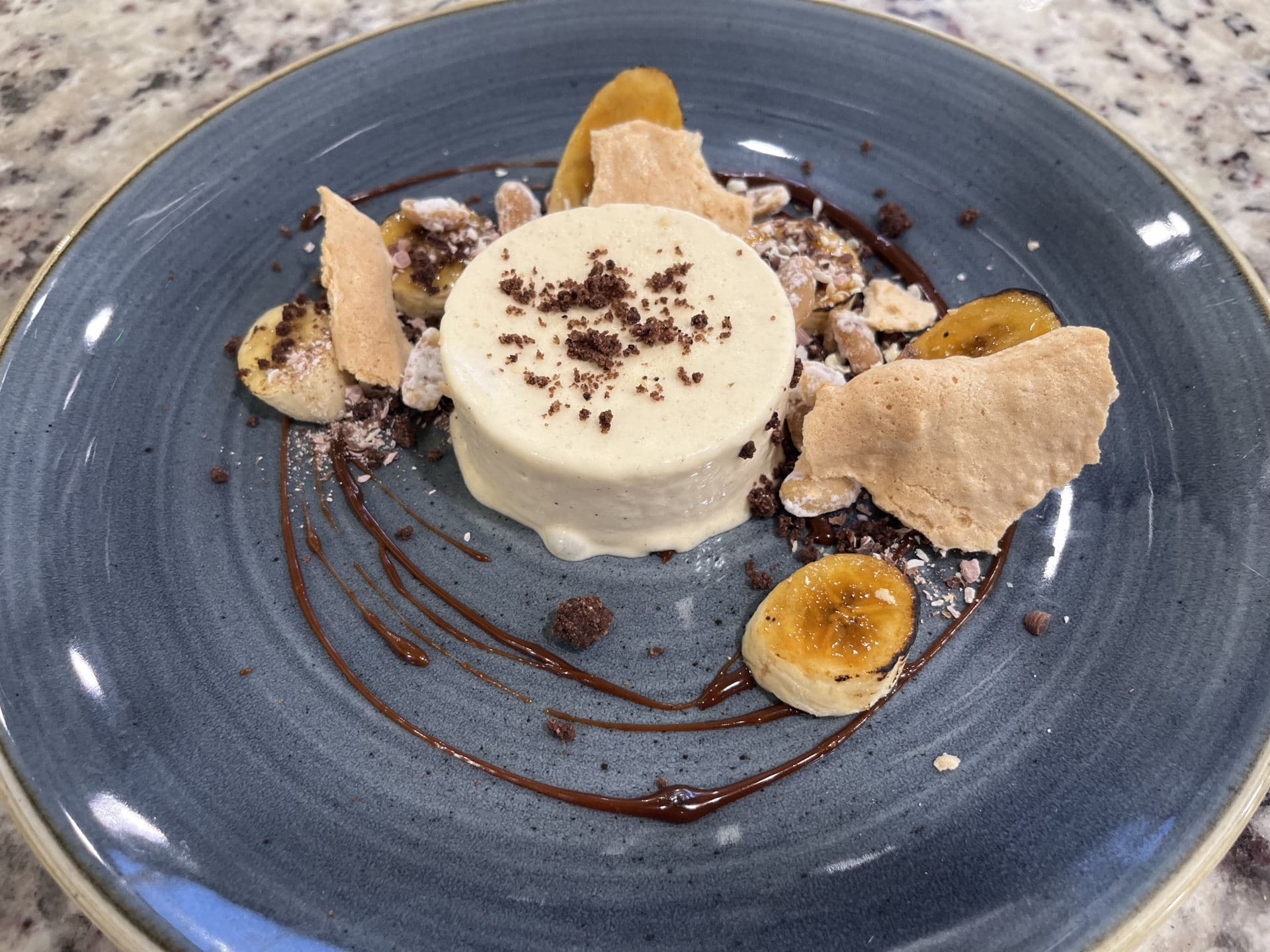 Burnt butter parfait with peanut crumb, caramelised banana, chocolate soil, and sea salt caramel sauce