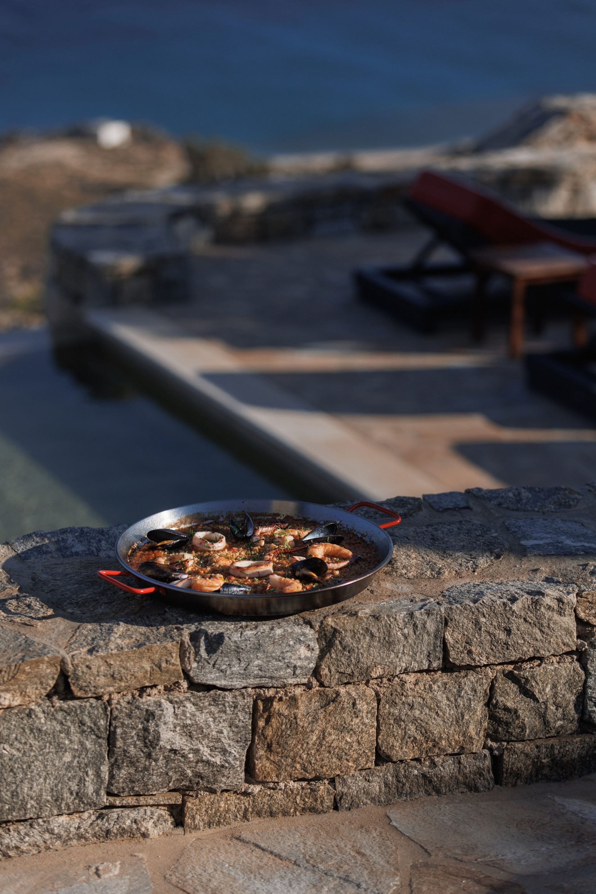 Seafood paella served beside the pool with sweeping sea views.