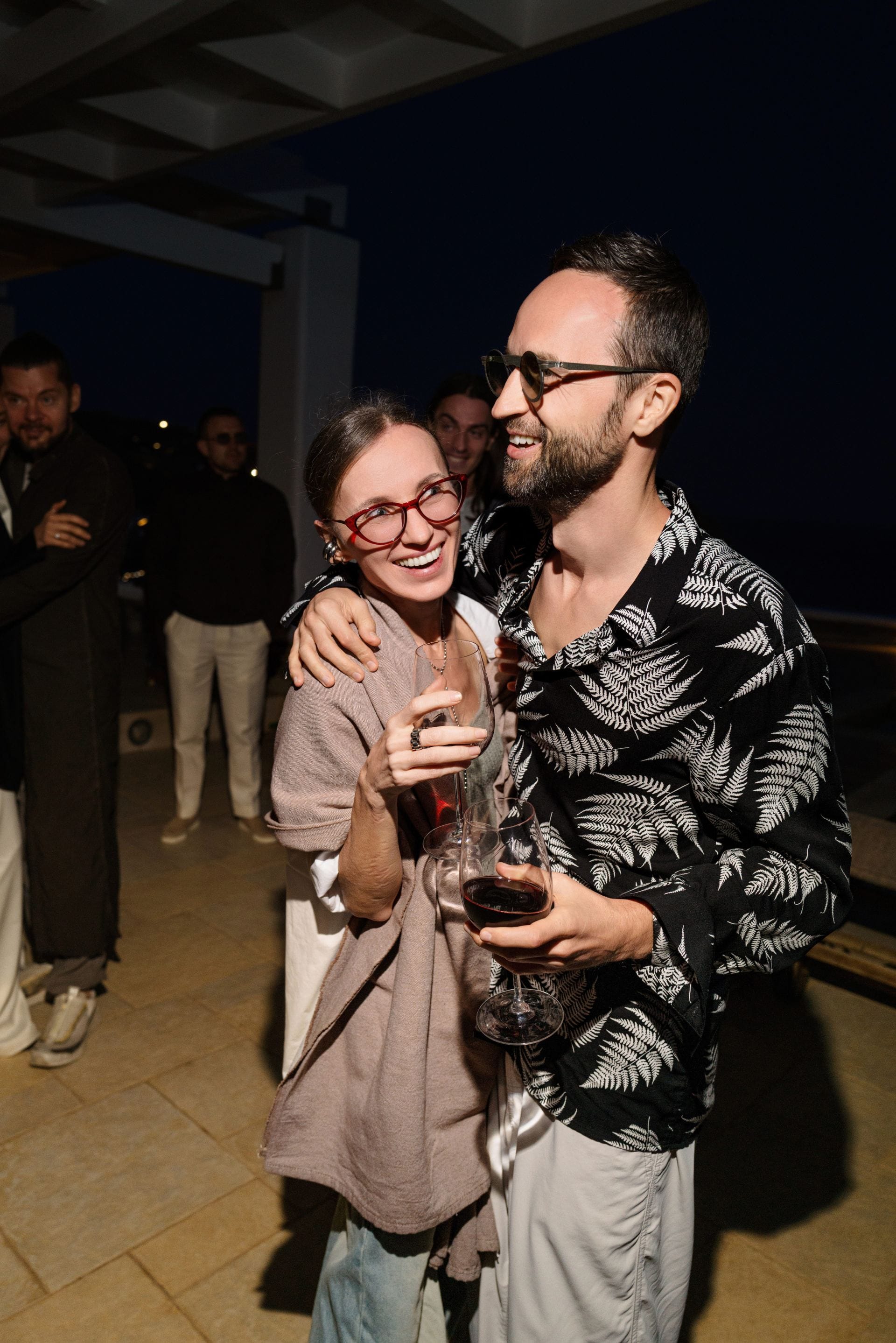 Couple enjoying drinks together at an intimate evening villa gathering.