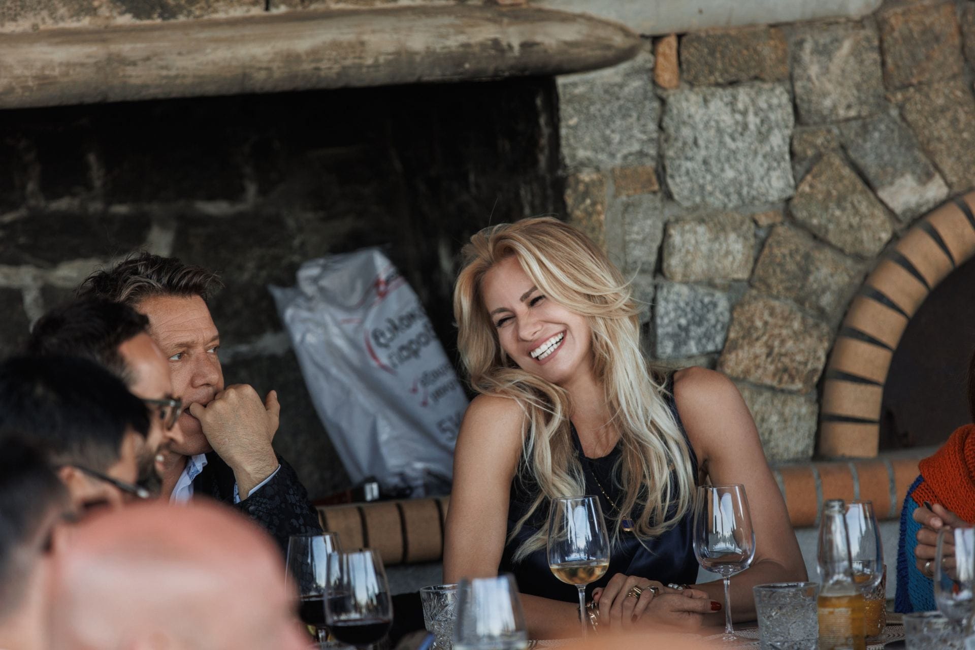 Guests sharing laughter over wine at a relaxed private villa gathering.