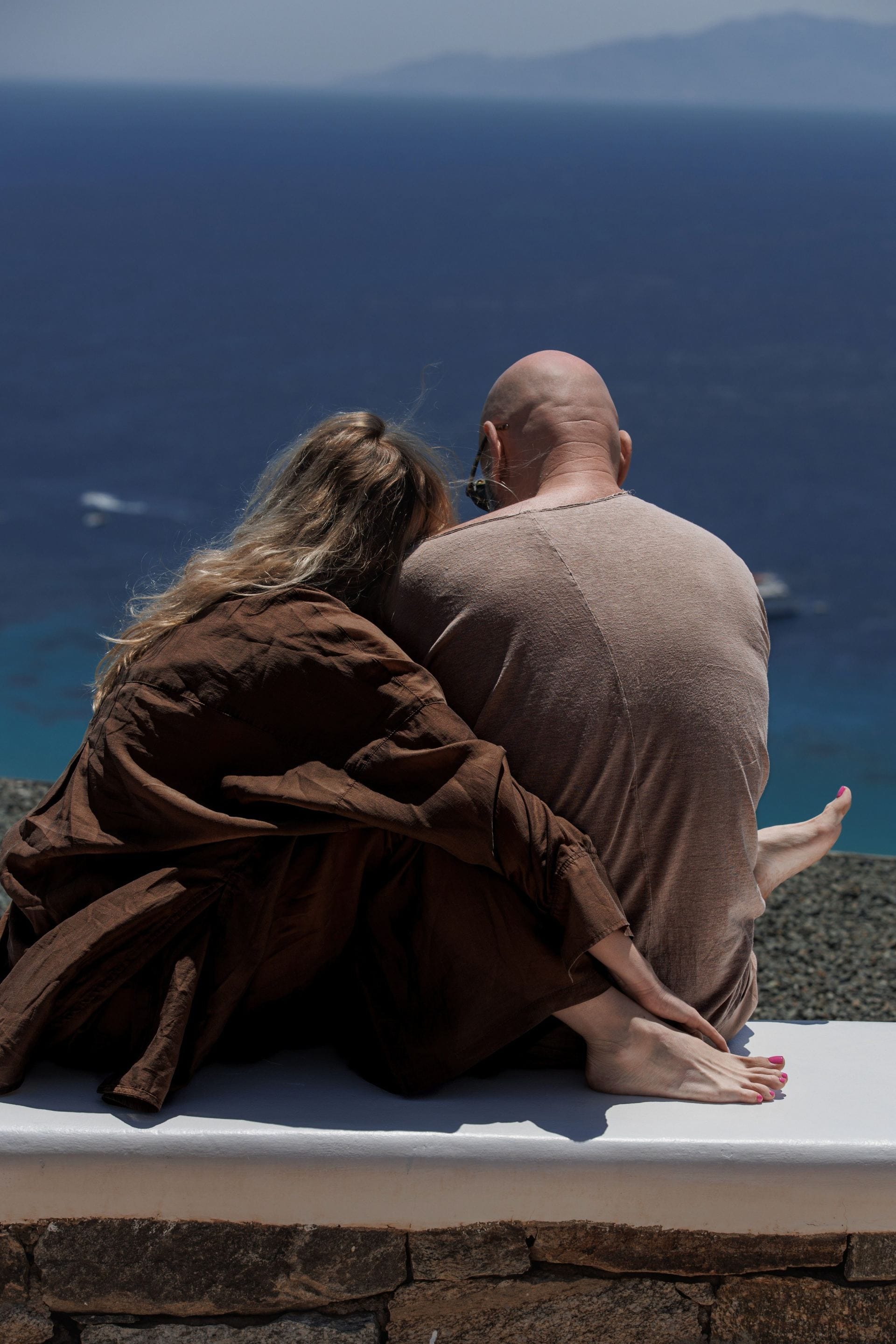 Couple relaxing together with sweeping views over the deep blue sea.